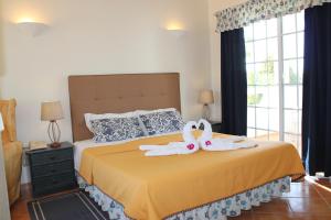 卡武埃鲁橄榄农场酒店的一间卧室,床上配有2条天鹅毛巾