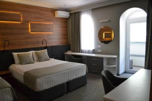 顿河畔罗斯托夫雪尔登酒店的配有一张床和一张书桌的酒店客房
