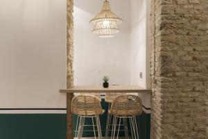 塞维利亚珀蒂宫卡纳莱哈斯塞维​​利亚酒店的厨房配有一张桌子和两张凳子