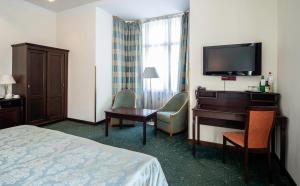 布拉格EA市区酒店的酒店客房配有一张床、一张书桌和一台电视。