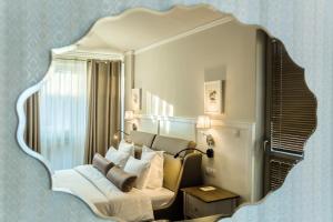 布尔加斯Hotel Residence Promenade的卧室配有大镜子,位于床上方