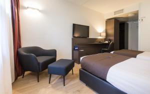 布森布森希尔弗瑟姆堡垒酒店的酒店的客房 - 带一张床、椅子和电视