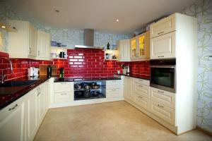 努克Eagle View的厨房配有白色橱柜和红砖墙