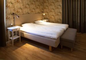 诺尔雪平Södra Hotellet的一张床位,位于带灯和床头柜的房间