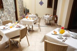 圣维托罗卡波Ninni e Fede的餐厅配有白色的桌椅,提供食物