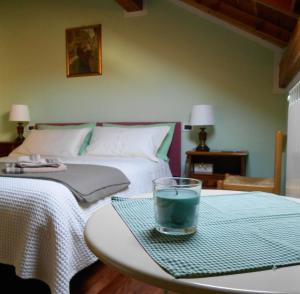 RossiglioneLa Stanza Verde的一间卧室配有一张床和一张桌子,上面有玻璃