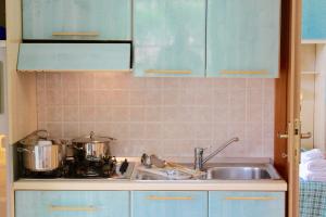 维耶斯泰Villaggio Turistico Defensola的厨房柜台配有2个锅和水槽