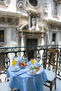 巴勒莫B&B Santa Caterina的阳台上的桌子上摆放着食物和饮料
