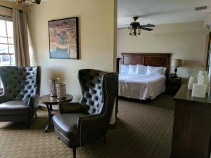 博尔德城博尔德大坝酒店的酒店客房,配有一张床和两把椅子