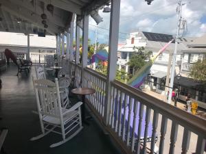 基韦斯特New Orleans House - Gay Male Adult Guesthouse的一个带椅子和桌子的门廊以及游乐场