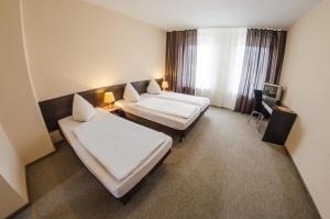 柏林维多利亚膳食公寓酒店的酒店客房设有两张床和窗户。
