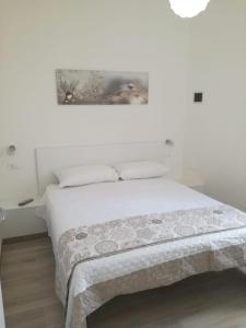加拉托内Cuore Galateo的白色的卧室,床上有毯子