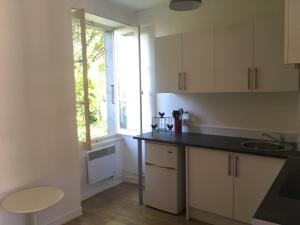 阿尔纳克－蓬帕杜尔Maison Lyre, Pompadour的厨房配有白色橱柜、水槽和窗户。