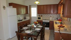 基普塞利Anastasia's House的厨房配有桌椅和冰箱。