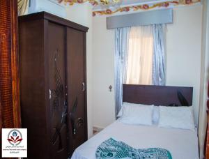 马特鲁港North Coast Princess Al Fayrouz的一间卧室配有一张带木制床头板的床