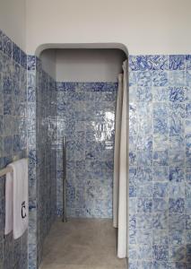 杜罗河畔瓦伦萨Quinta da Côrte的浴室设有蓝色瓷砖墙壁和淋浴。