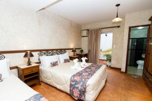 卡波布里奥Pousada Brasil Nativo的酒店客房设有两张床和窗户。