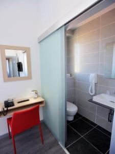 蒙特卡罗法国酒店的一间带卫生间、水槽和红色椅子的浴室