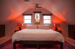 新奥尔良Royal Street Inn & Bar的卧室配有一张白色大床和两个窗户