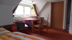 博恩Urlaub bei Hauenstein的一间卧室配有桌椅和一张床