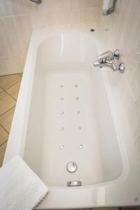 德科克斯多普Studio's De Vlijt Texel的浴室内设有带水龙头的白色浴缸