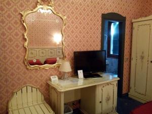 威尼斯安缇卡帕纳达酒店的客房设有一张带电脑和镜子的书桌