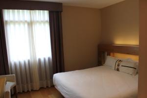 La Pereda de Llanes拉昆塔伊森西亚酒店的卧室配有白色的床和窗户。
