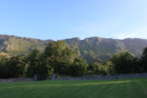 La Pereda de Llanes拉昆塔伊森西亚酒店的山地,有围栏,有山地背景