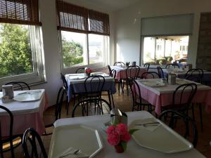 马达莱纳尼多达图依拉酒店的用餐室配有桌椅、粉色和白色的桌子