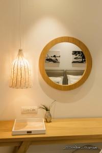 帕尔加Alfa Hotel的木桌上方的一面镜子,上面有板子