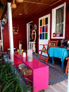 锡德Side Tuana Garden Home的红色的房子,配有桌子和蓝色桌子