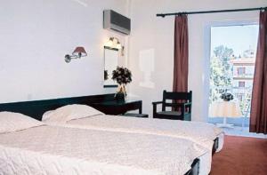 克兰尼蒂Ermionida的一间卧室配有一张床、一张书桌和一个窗户。