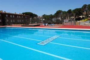 卡莱利亚德帕拉弗鲁赫尔Apartamentos Margell的一个带篮球场的大型蓝色游泳池