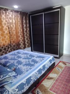 峇六拜纳德拉小屋民宿的一张位于带大窗户的房间内的床铺