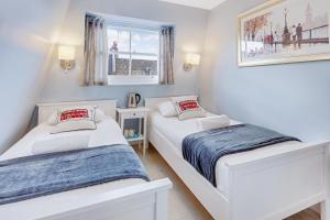 伦敦肯辛顿阿斯特旅舍的配有2张床的白色墙壁和窗户。