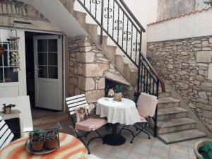 尼亚卢卡Apartments Ani的一个带石墙的庭院里的桌椅