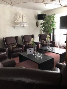 埃克勒伊克罗餐厅酒店的一间设有皮沙发和桌子的等候室