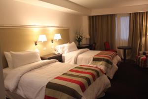 布宜诺斯艾利斯弗朗西丝酒店及俱乐部的酒店客房带两张床和一张桌子以及椅子。