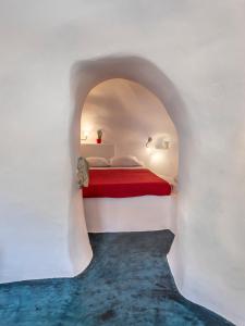 安坡里奥圣托里尼Traditional Farmers Caves的卧室配有白色墙壁上的床铺