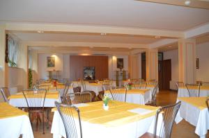 斯波莱托卡萨•瑞丽吉奥萨•迪•欧斯匹塔利塔•纳扎雷诺酒店的一间设有白色桌椅的用餐室