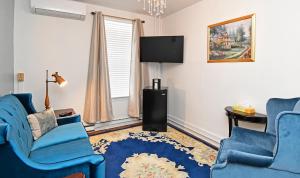 伯克利斯普林斯伯克利斯普林斯乡村旅馆的客厅配有2把蓝色椅子和电视