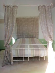 库特罗菲安诺I fichi bianchi的卧室内带窗帘的房间的一张床位