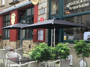 圣马洛Hotel Brasserie Armoricaine的餐厅前的2张桌子和椅子及遮阳伞