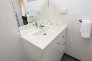 米尔迪拉七松汽车旅馆的白色的浴室设有水槽和镜子