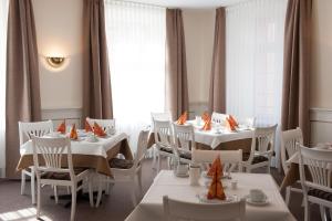 埃赫施塔特Hotel Adler的用餐室配有白色的桌子和白色的椅子