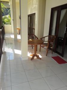 艾湄湾Tanaya Homestay的客房铺有瓷砖地板,配有桌椅。