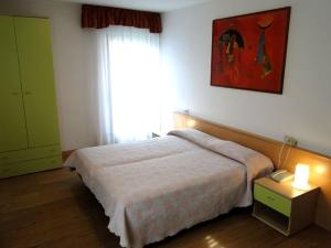 费拉迪普利米罗Albergo Dolomiti的一间卧室设有一张大床和一个窗户。