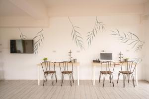 涛岛The Dearly Koh Tao Hostel-PADI 5 Star Dive Resort的用餐室配有椅子和一张桌子,墙上挂着树叶