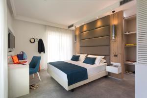 里米尼阿索托丽亚套房酒店的一间卧室配有一张床、一把椅子和一张书桌