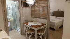 威尼斯La Bonbonnier的小房间设有一张床、一张桌子和椅子
